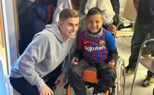Fermín López con un fan en silla de ruedas