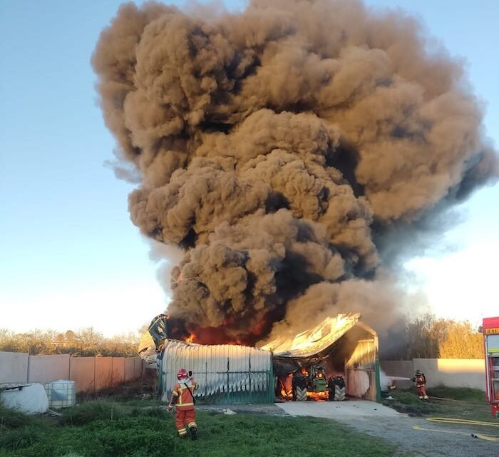 El incendio de un tractor en una nave de Moguer causa una enorme columna de humo