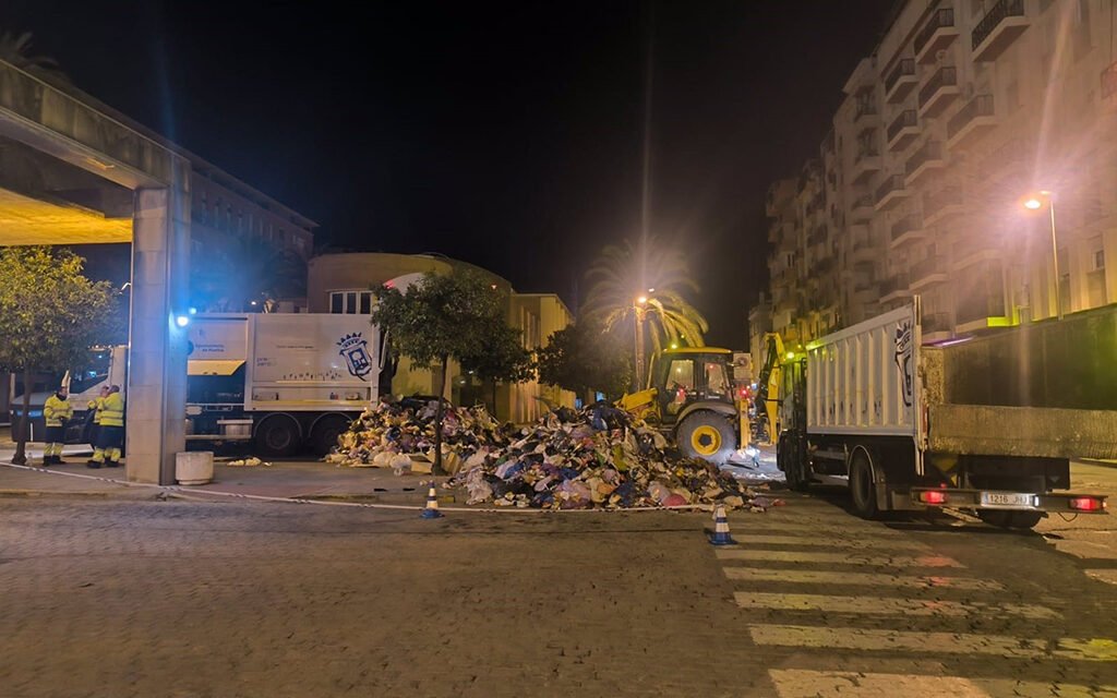 Un hombre cae a un camión de la basura desde un contenedor